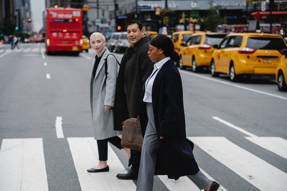 Three people crossing the light in the Streets of New York City