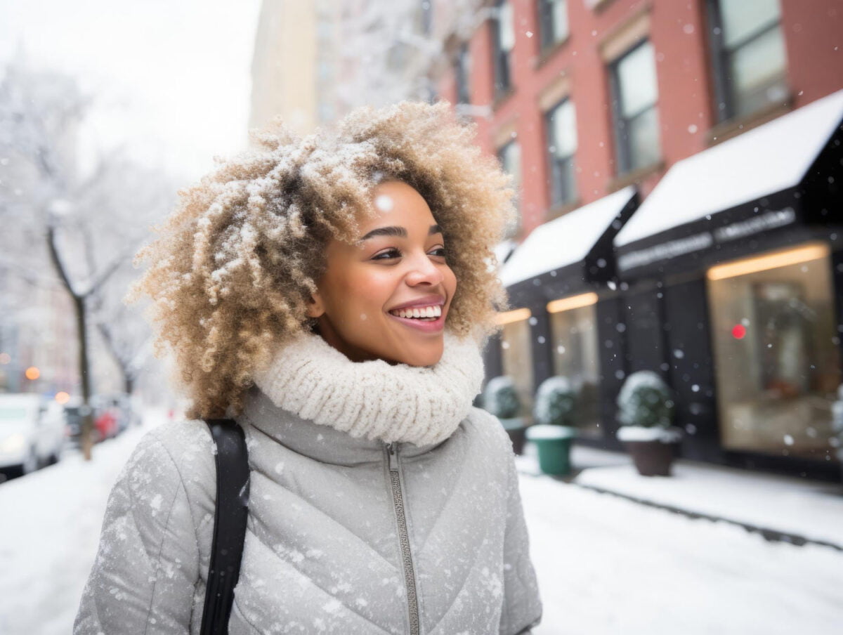 woman smiling in the street of NYC while it's snowing