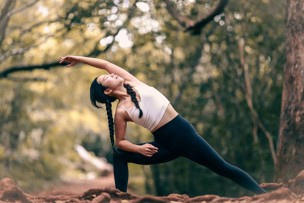 Woman in fitness clothes stretching in nature doing yoga