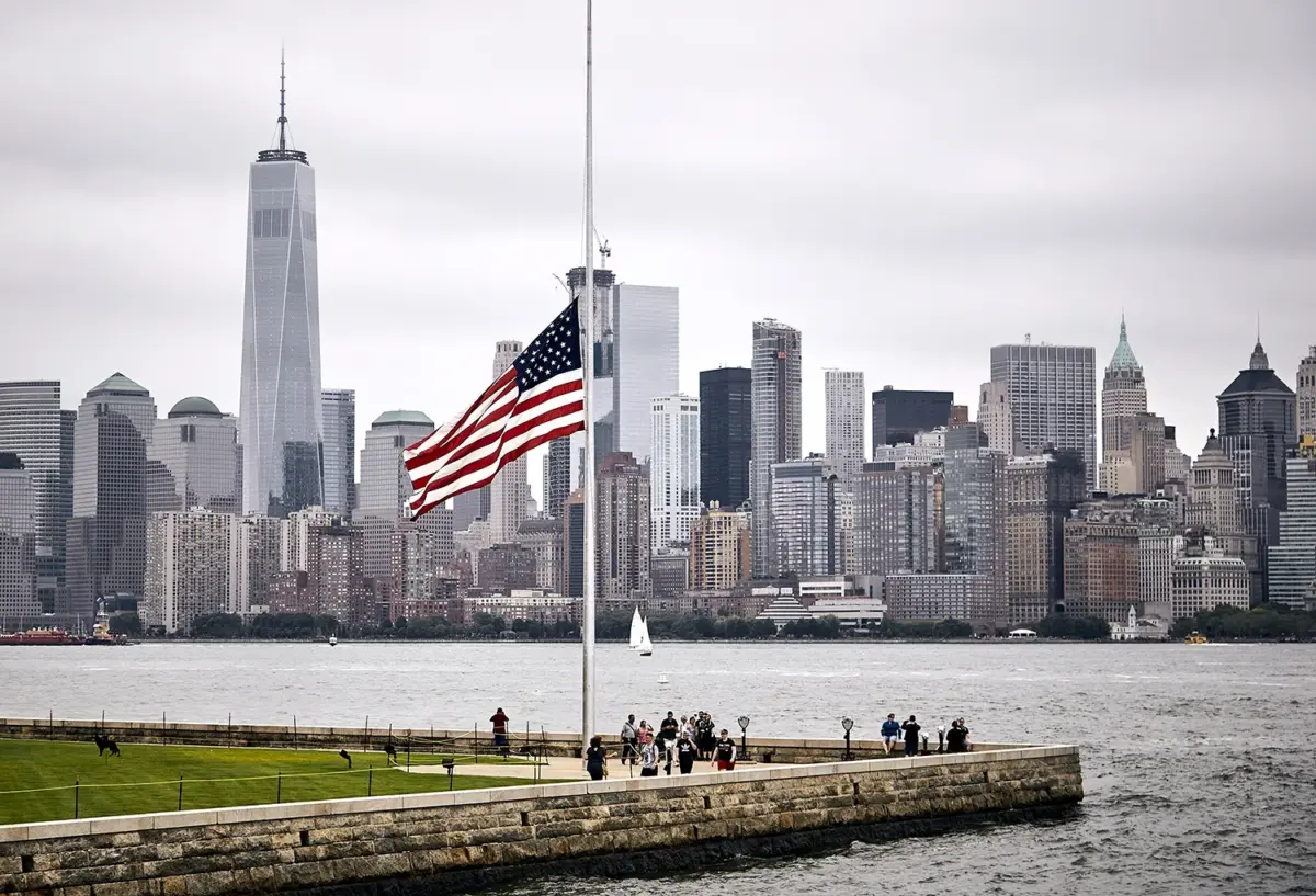 View of Ellis Island with Manhattan in the back and a Flag of the United States
